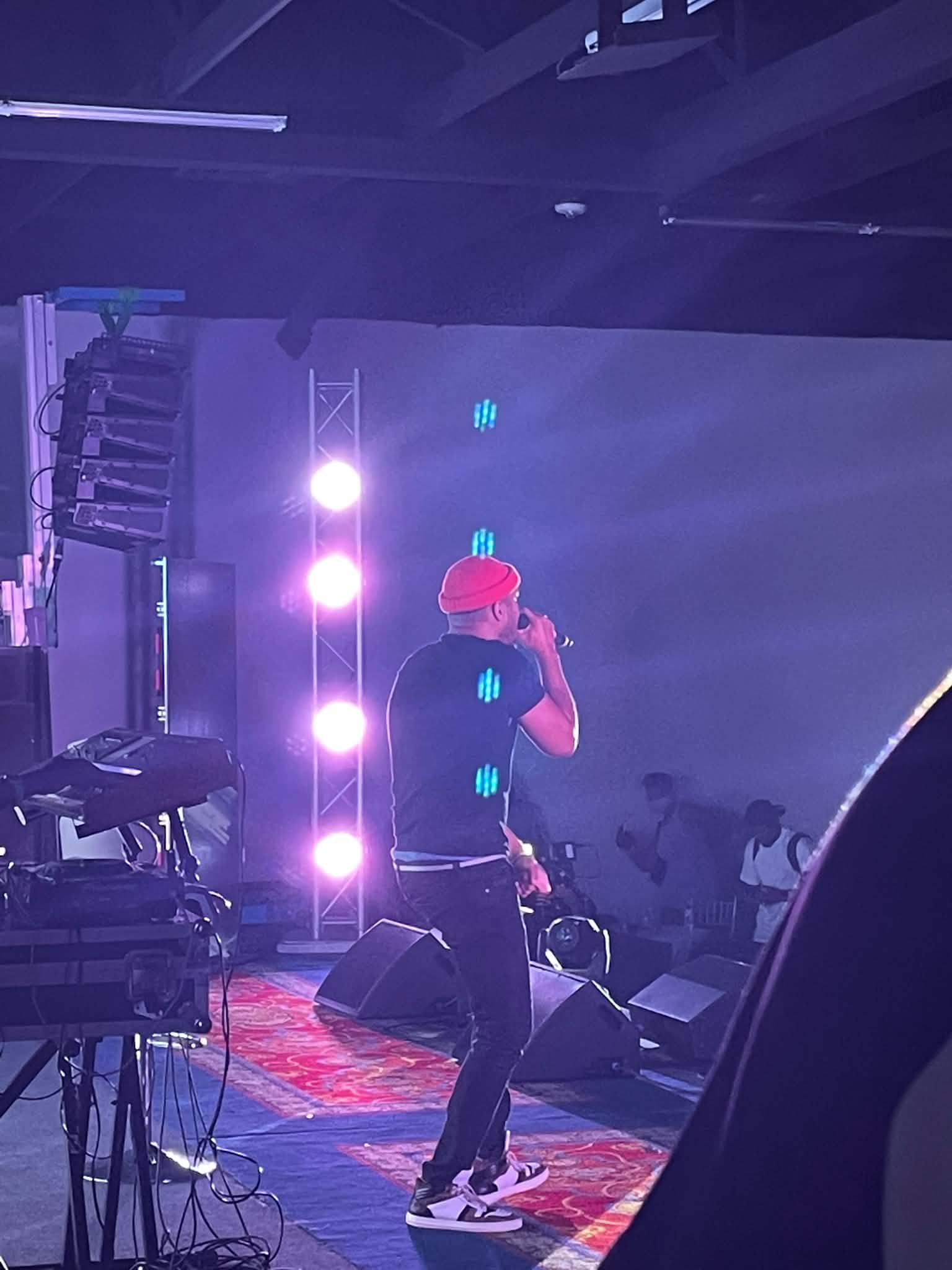 A performer on stage under purple lights at A Night With Lyfe Jennings