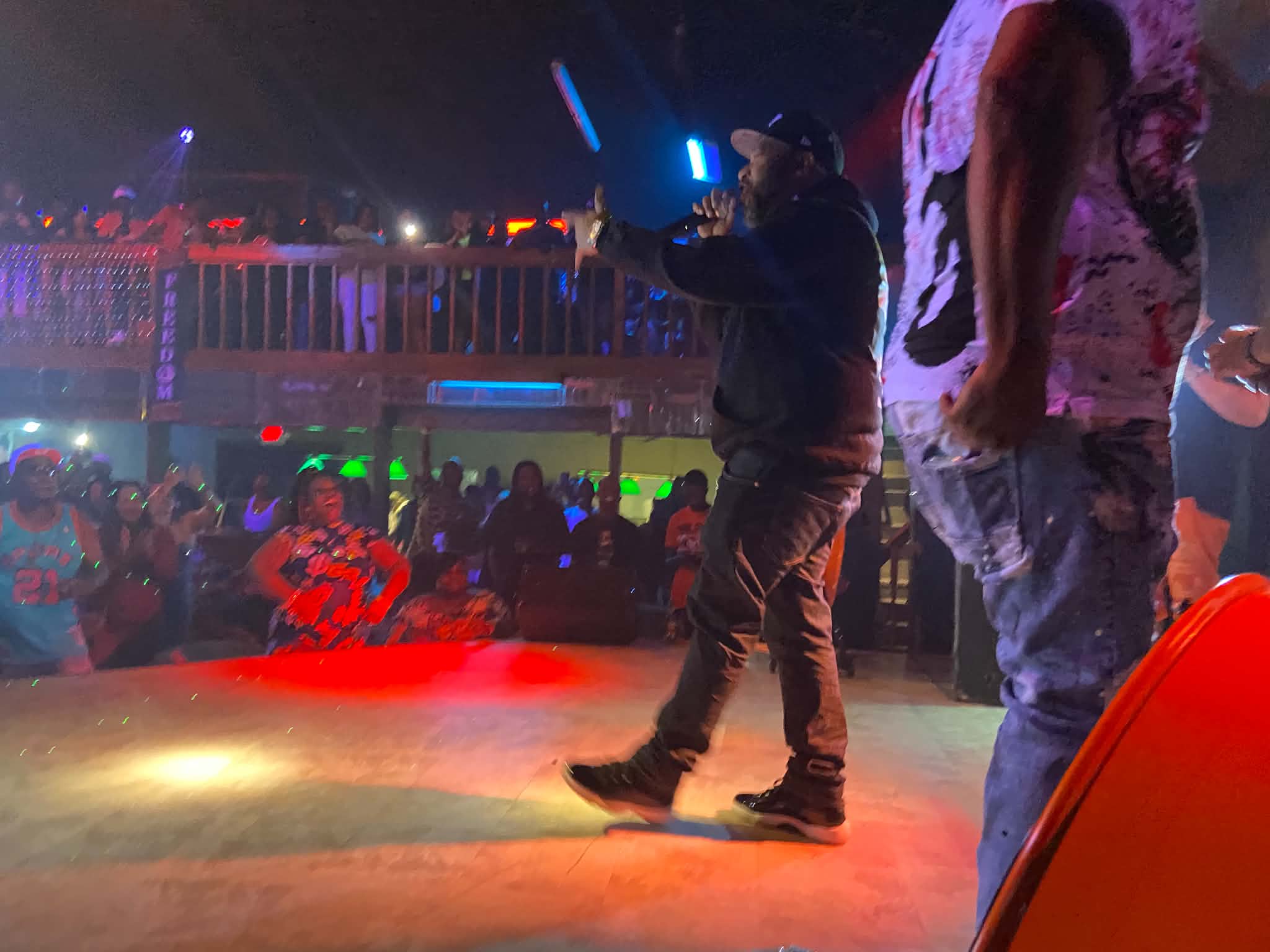 A performer with a microphone in front of the crowd at A Night of Our Independence